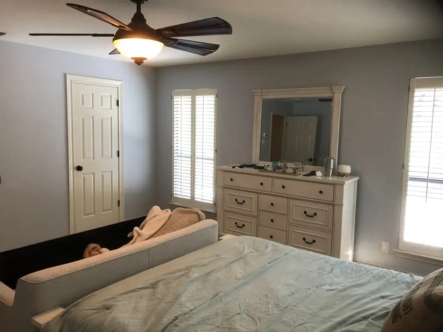 Bedroom with the bed and furnishings covered and protected before painting