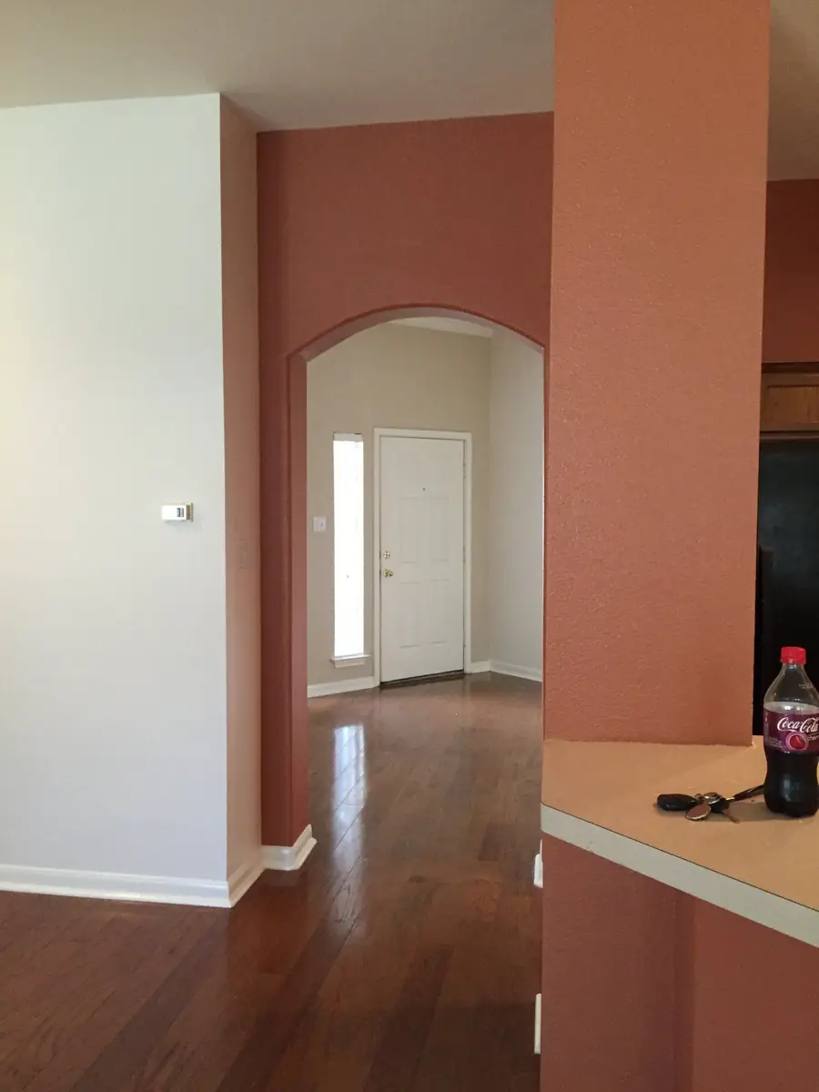 Entry hall with a terracotta accent wall, white door and trim after repainting